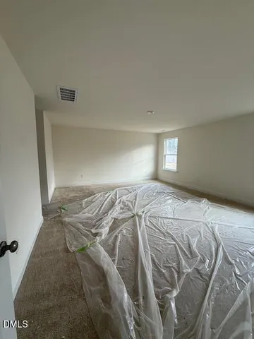 a bed sitting in a bedroom next to a window