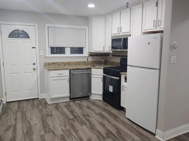 a kitchen with white cabinets and white appliances