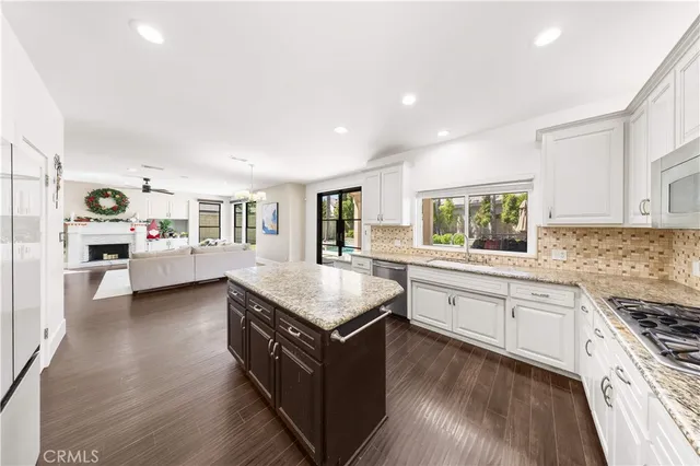 a kitchen with granite countertop a sink stove and cabinets