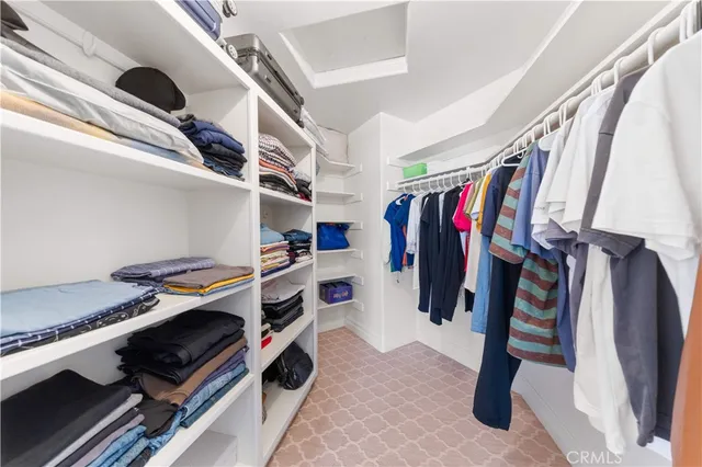 a view of walk in closet with clothes and shoes