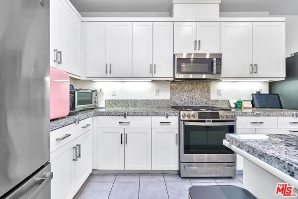 a kitchen with white cabinets and white appliances
