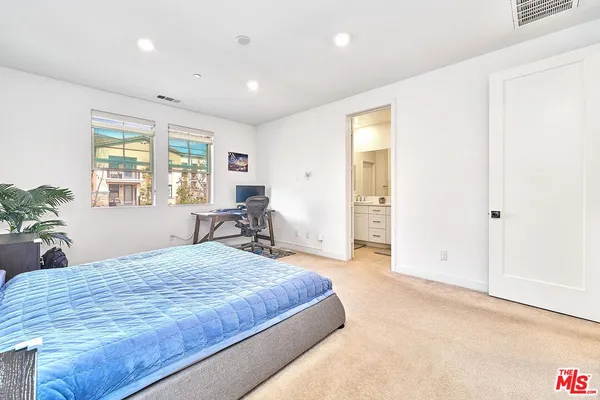 a spacious bedroom with a large bed and a chandelier
