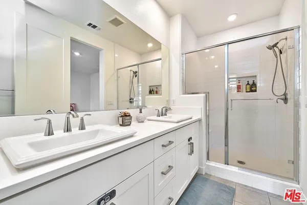 a bathroom with a double vanity sink mirror double and shower