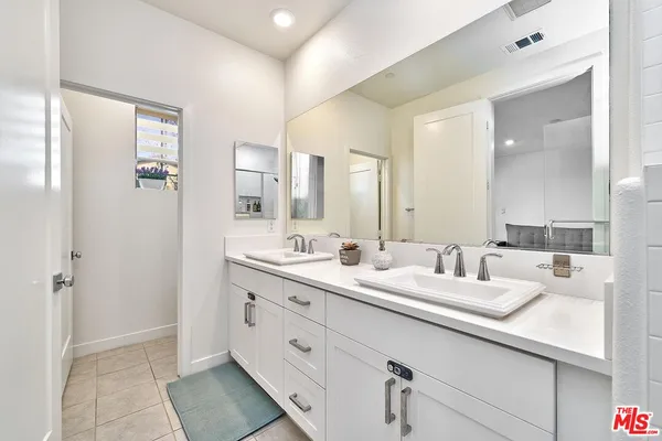 a bathroom with a double vanity sink and mirror