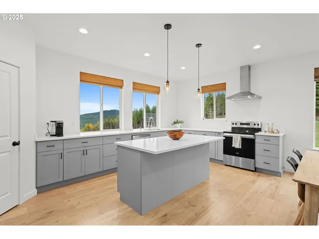 a kitchen with stainless steel appliances granite countertop a sink a stove and a refrigerator