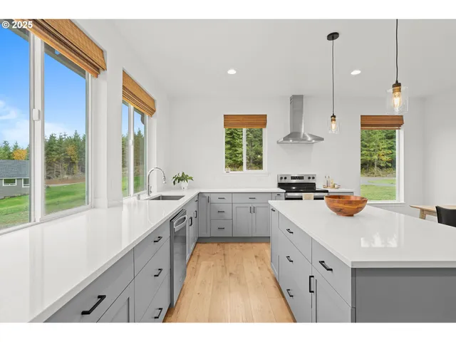 a large kitchen with kitchen island granite countertop a sink a counter space appliances and a window