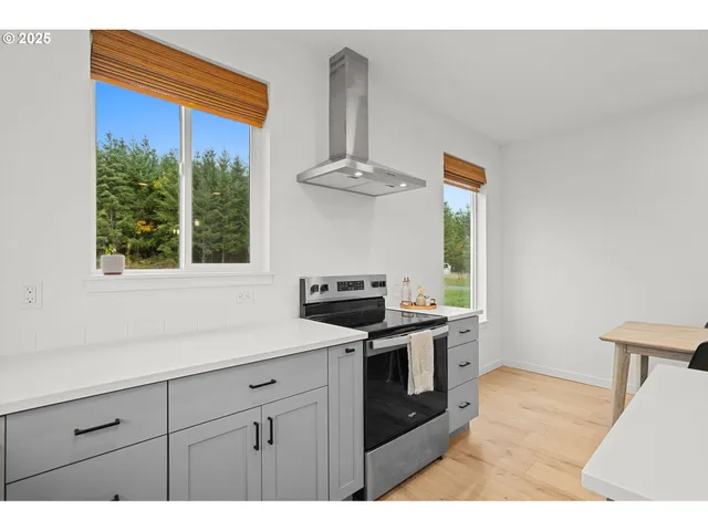 a kitchen with stainless steel appliances granite countertop a sink a stove and a wooden floors