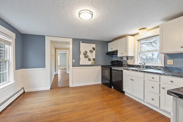a kitchen with granite countertop a stove a sink and a refrigerator