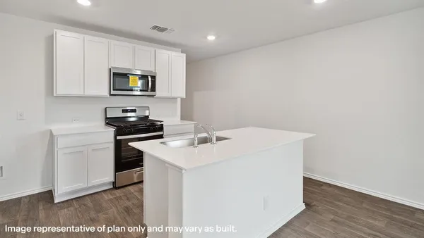 a kitchen with a sink a microwave and cabinets
