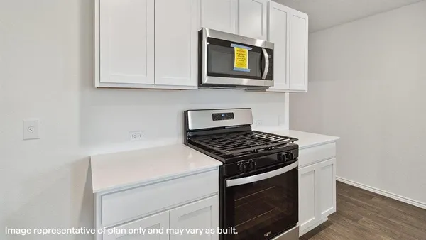 a kitchen with stainless steel appliances granite countertop white cabinets a stove top oven
