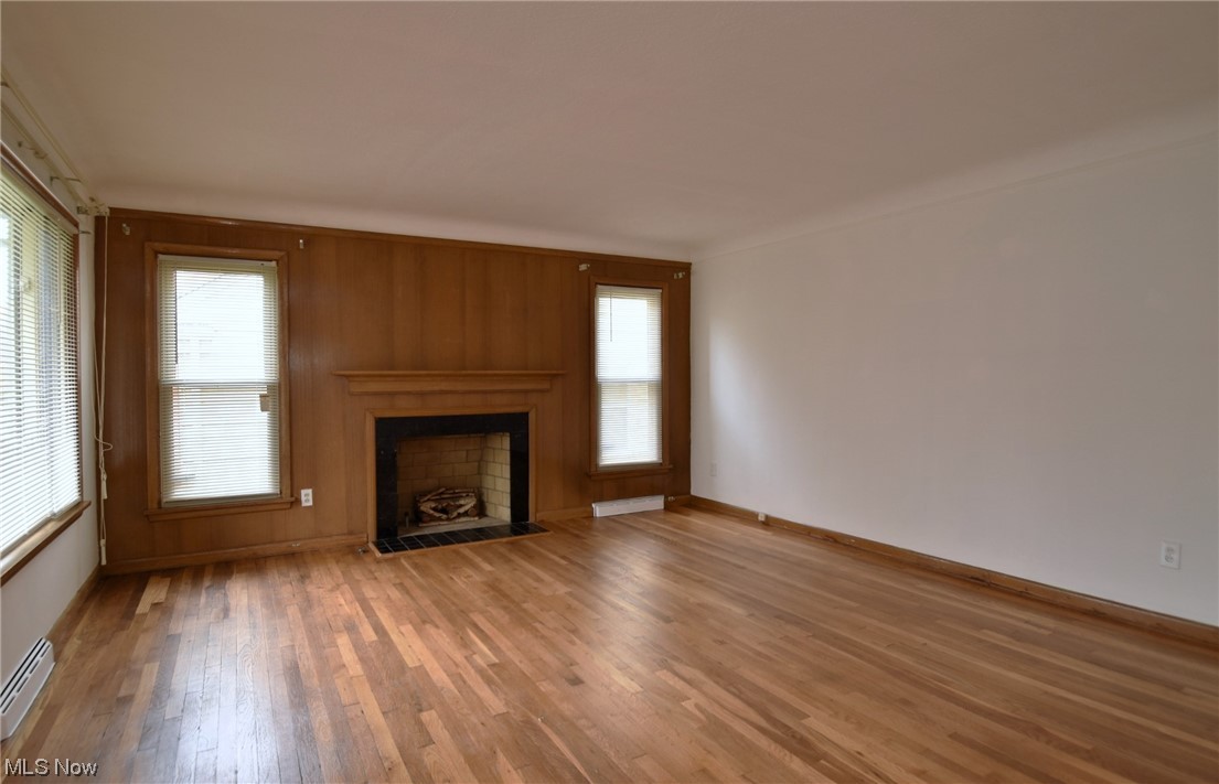 3681 Brinkmore Road Cleveland Heights, OH 44121 - Photo 4 of 27 Unfurnished living room with wooden walls, light wood-type flooring, and plenty of natural light