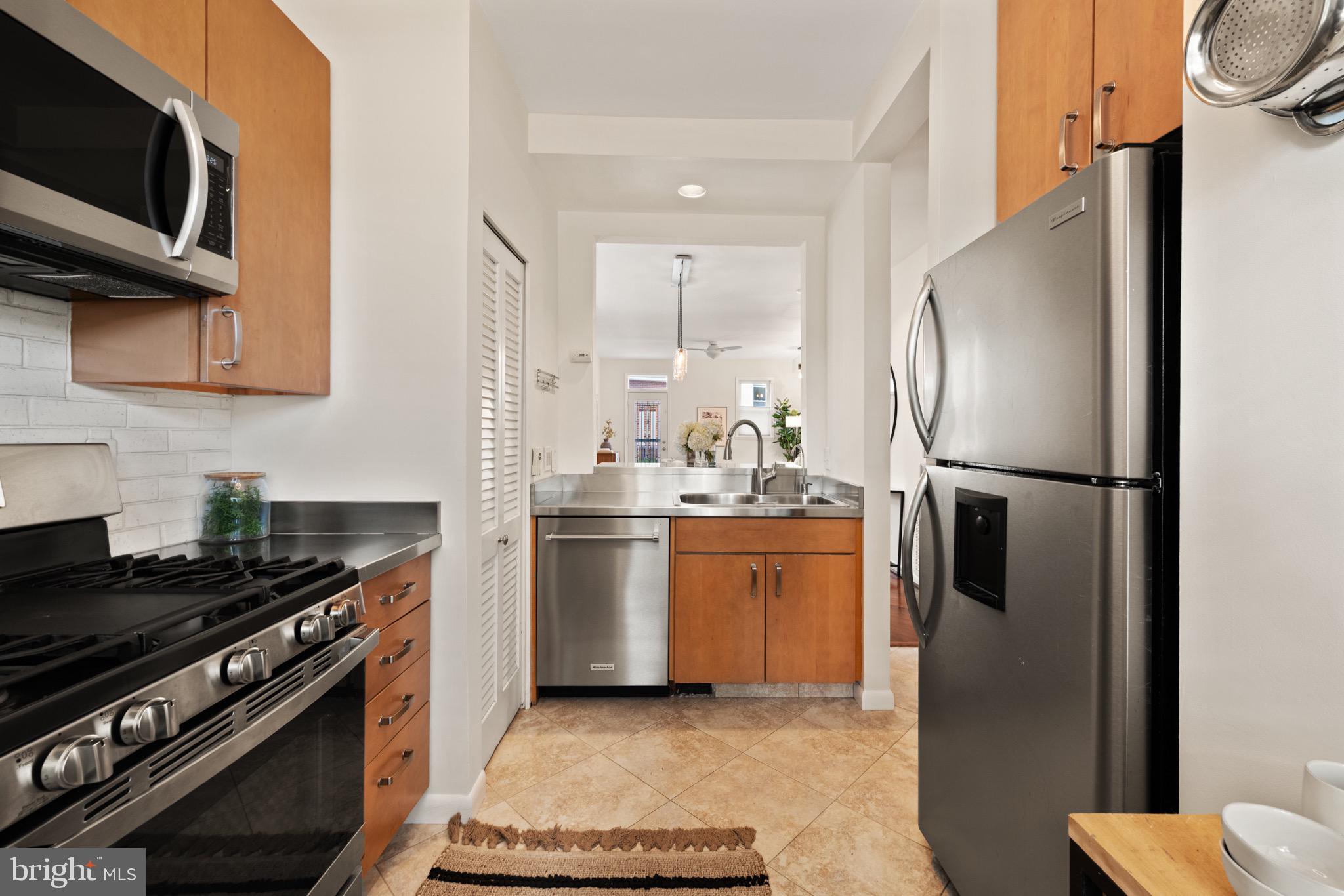 1641 V Street Northwest Washington, DC 20009 - Photo 10 of 36 a kitchen with stainless steel appliances granite countertop a refrigerator stove and microwave