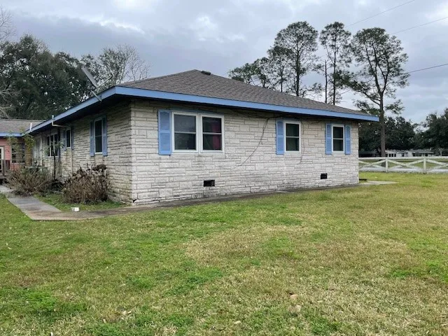 a front view of house with yard and trees in the background