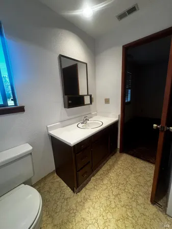 a bathroom with a sink a toilet and mirror