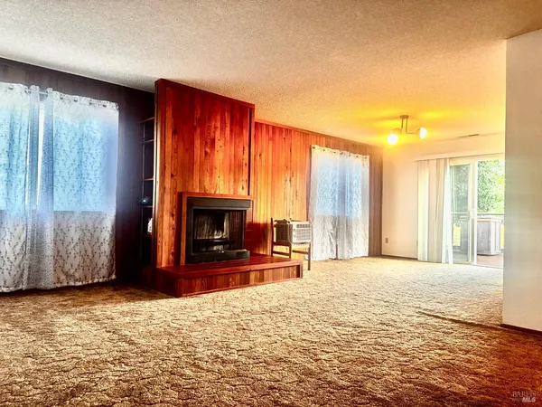 a view of a livingroom with a fireplace a window and a fireplace