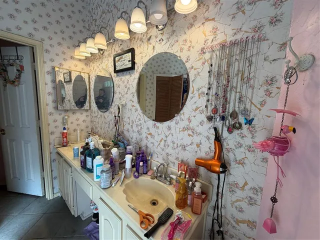 a bathroom with a sink mirror and vanity