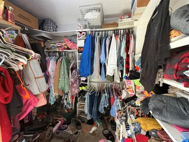 a view of walk in closet with clothes