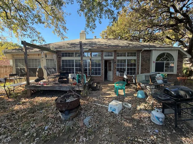a view of a patio with table and chairs barbeque potted plants and large tree