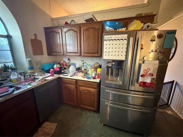 a kitchen with stainless steel appliances granite countertop a refrigerator and a sink
