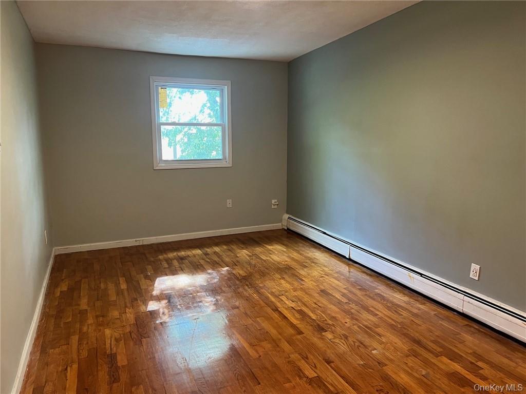 708 Silver Lake-Scotchtown Road Middletown, NY 10941 - Photo 21 of 25 Unfurnished room featuring dark wood-type flooring and a baseboard radiator