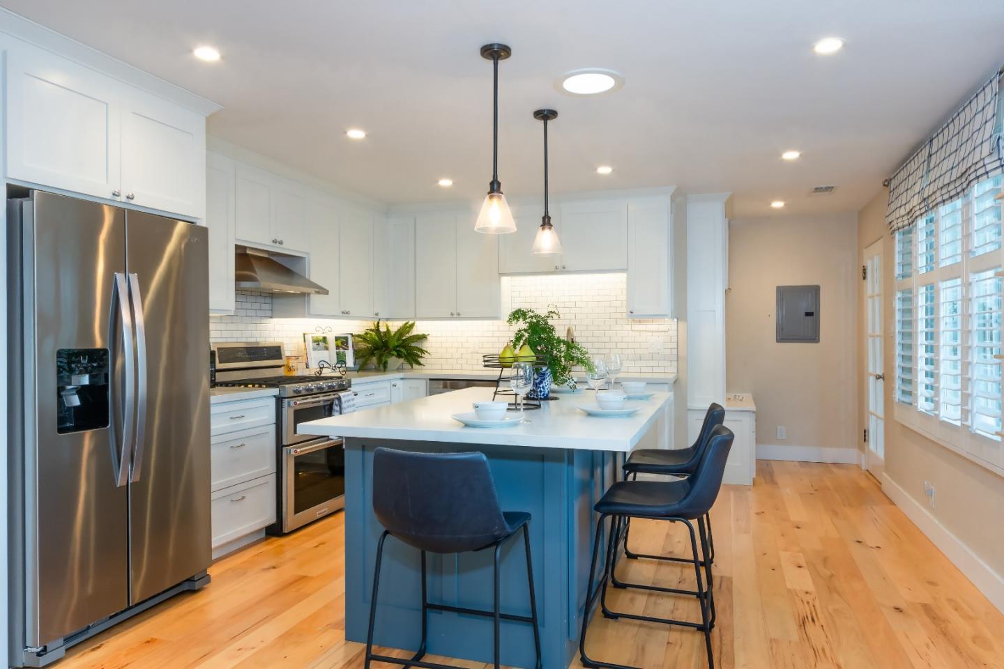 340 Jarvis Court Sunnyvale, CA 94086 - Photo 7 of 18 a kitchen with stainless steel appliances kitchen island granite countertop a dining table chairs refrigerator and sink