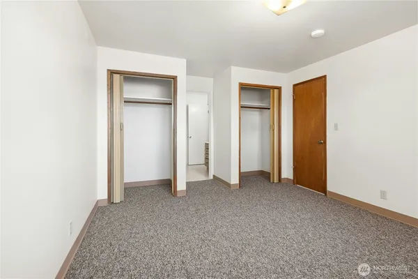 an empty room with closet and a bathroom