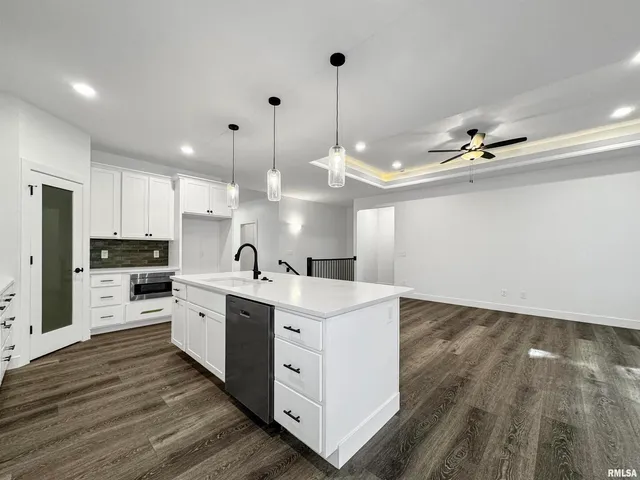 a view of a kitchen with kitchen island a sink stainless steel appliances and cabinets