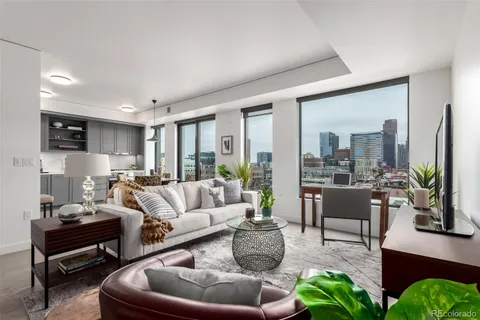 a living room with furniture potted plant a fireplace and a large window