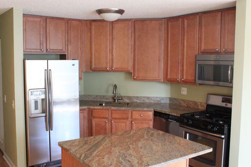 Undisclosed Address Chicago, IL 60654 - Photo 2 of 10 a kitchen with stainless steel appliances granite countertop a stove a refrigerator and a sink with wooden cabinets