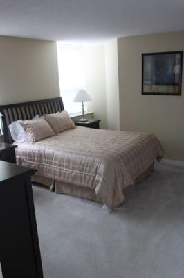 Undisclosed Address Chicago, IL 60654 - Photo 5 of 10 a bedroom with a bed and a night stand