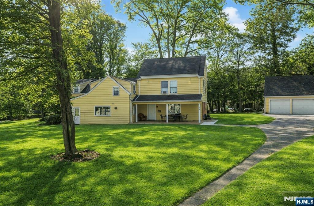 a front view of a house with a yard and trees