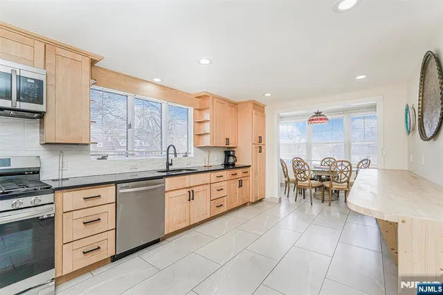 a large kitchen with kitchen island granite countertop a table and chairs in it