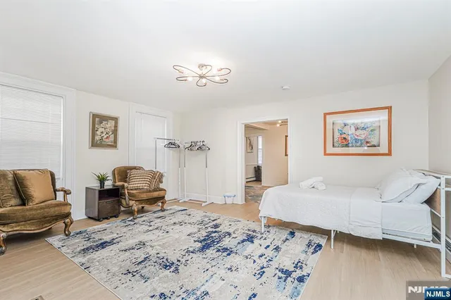 a bedroom with a bed couch and wooden floor