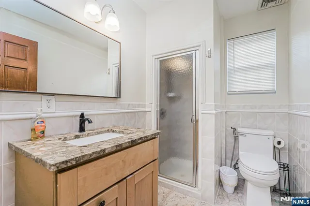 a bathroom with a granite countertop sink toilet and shower