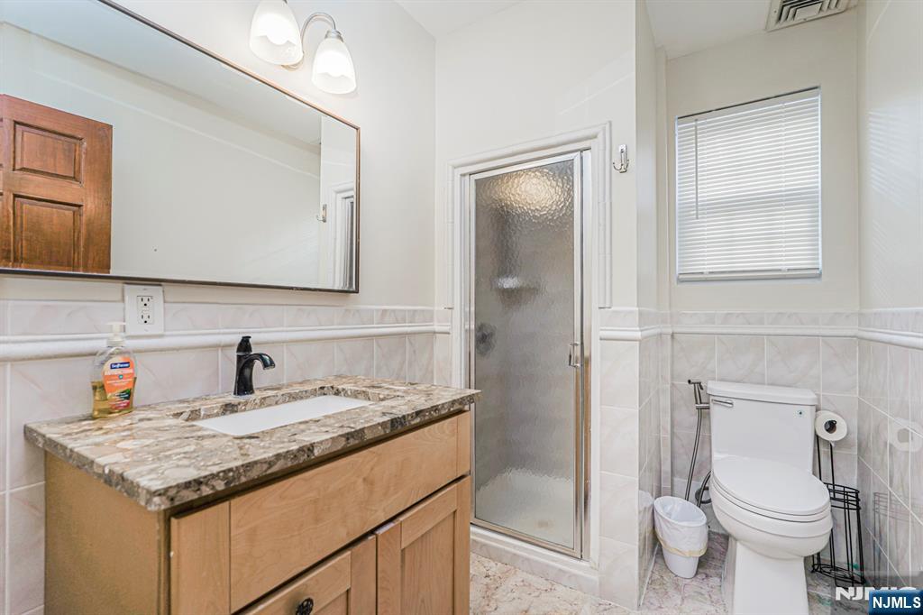 566 Teaneck Road Teaneck, NJ 07666 - Photo 26 of 35 a bathroom with a granite countertop sink toilet and shower