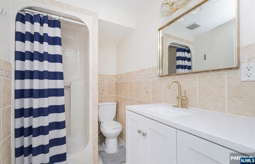 566 Teaneck Road Teaneck, NJ 07666 - Photo 31 of 35 a bathroom with a sink a toilet and a mirror