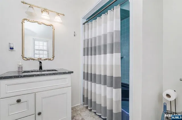 a bathroom with a granite countertop sink and a mirror