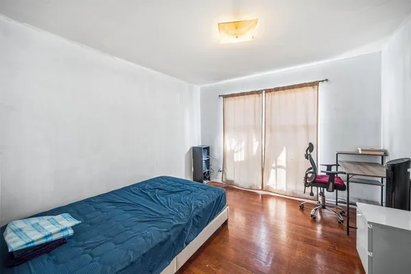 a room with a bed and wooden floor