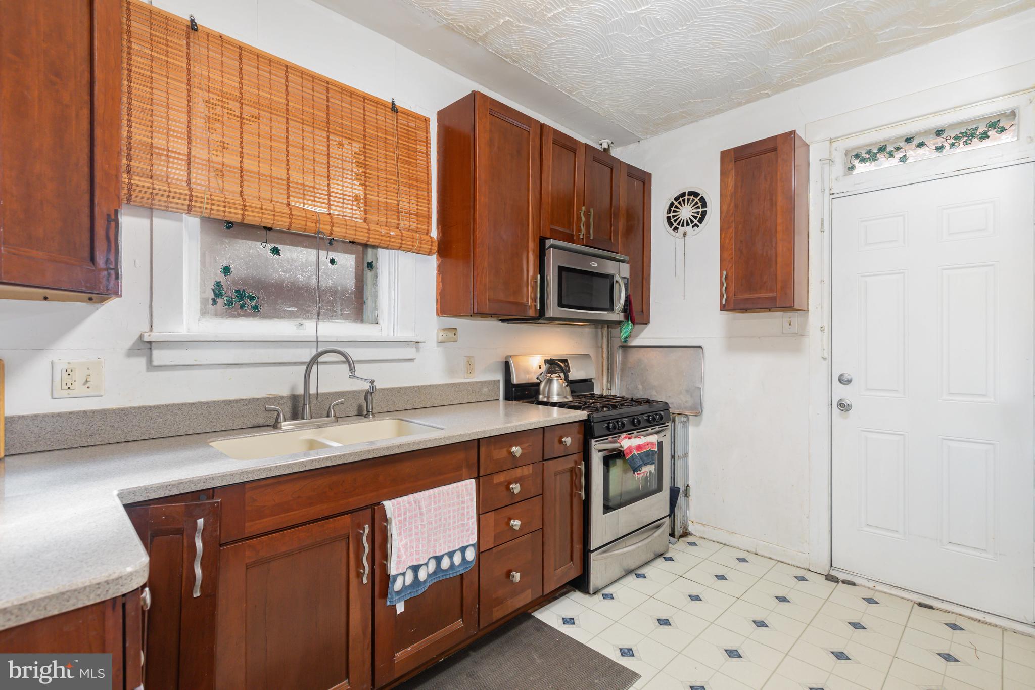 1204 North 16th Street Harrisburg, PA 17103 - Photo 11 of 30 a kitchen with stainless steel appliances granite countertop a sink stove and refrigerator