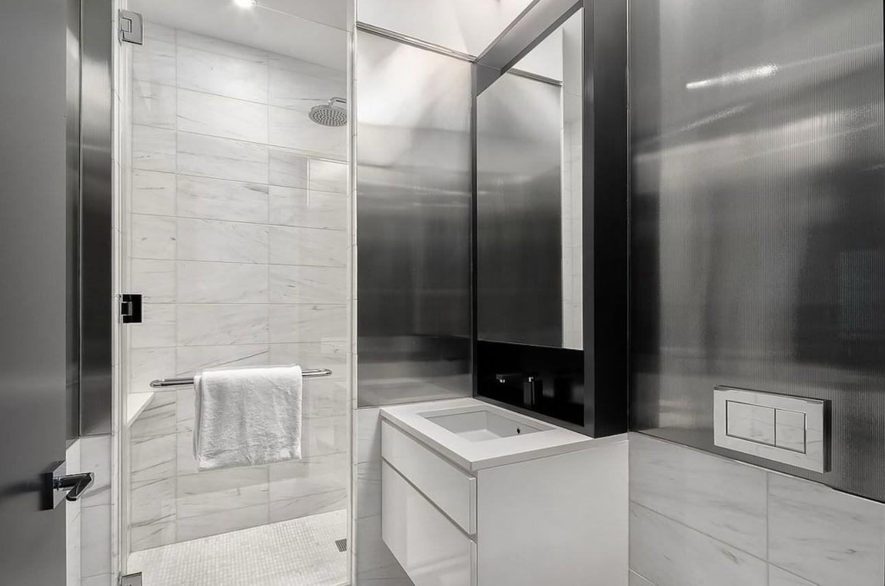 157 West 57th Street, Unit 33E Manhattan, NY 10019 - Photo 6 of 12 Bathroom with vanity and a shower with shower door