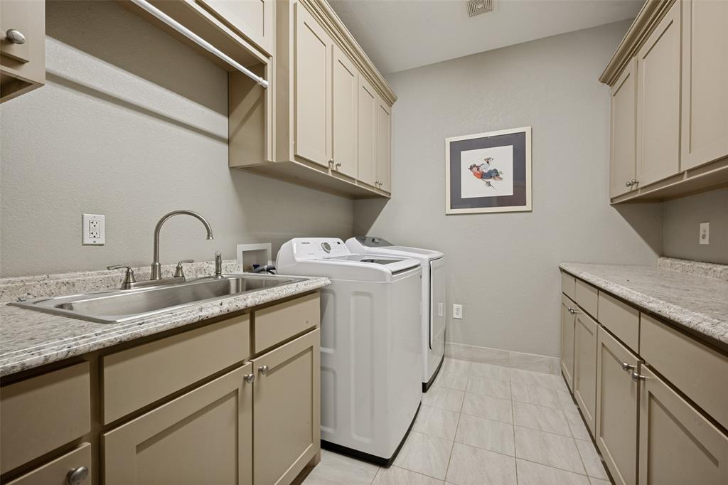8400 Holder Road Northlake, TX 76247 - Photo 14 of 36 Laundry room featuring extensive cabinetry, a stainless steel utility sink, composite countertops, and tile flooring