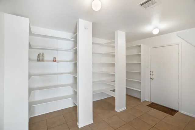 a view of walk in closet with empty racks