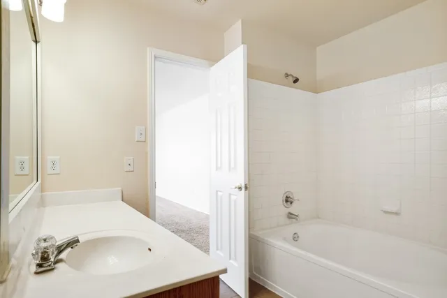 a bathroom with a tub sink and vanity