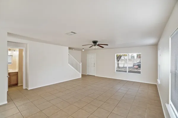an empty room with windows and fan