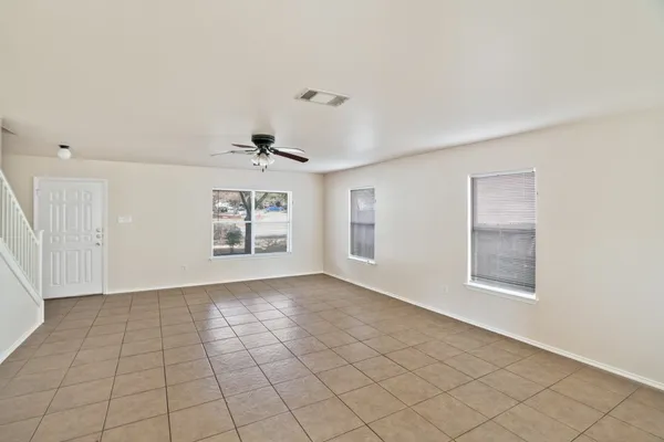 an empty room with windows and fan
