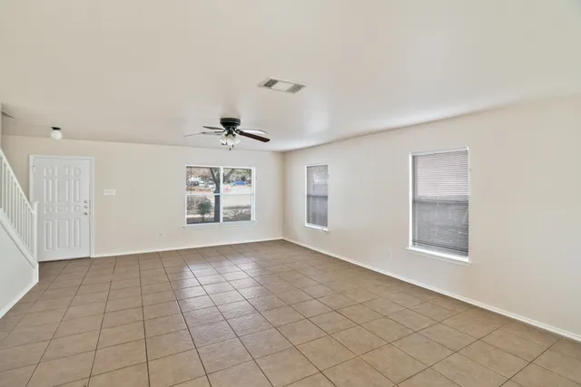 an empty room with windows and fan