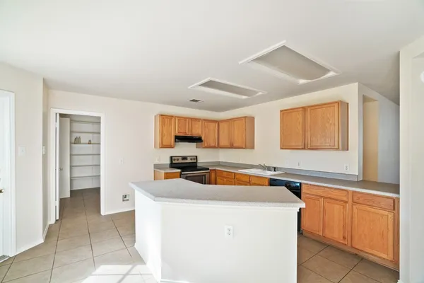 a kitchen with a sink a stove cabinets and a window
