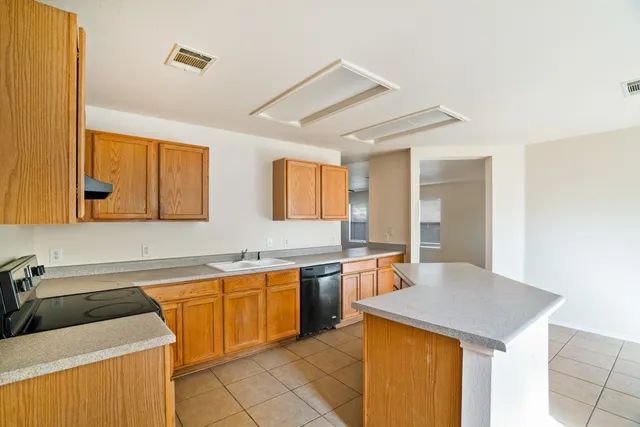 a kitchen with a sink a stove and cabinets