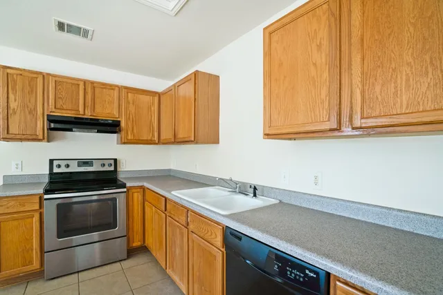 a kitchen with stainless steel appliances granite countertop a sink a stove and a microwave