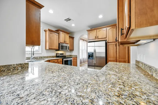 a kitchen with a sink a counter top space cabinets and stainless steel appliances